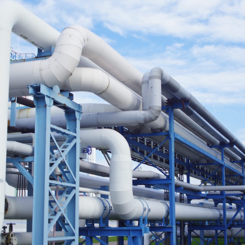 A closeup of industrial pipelines around a factor on a sunny day